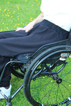 Close-up side view of Vilber's adaptive joggers showing the elasticated waistband and smooth fabric across the hip in a seated position.