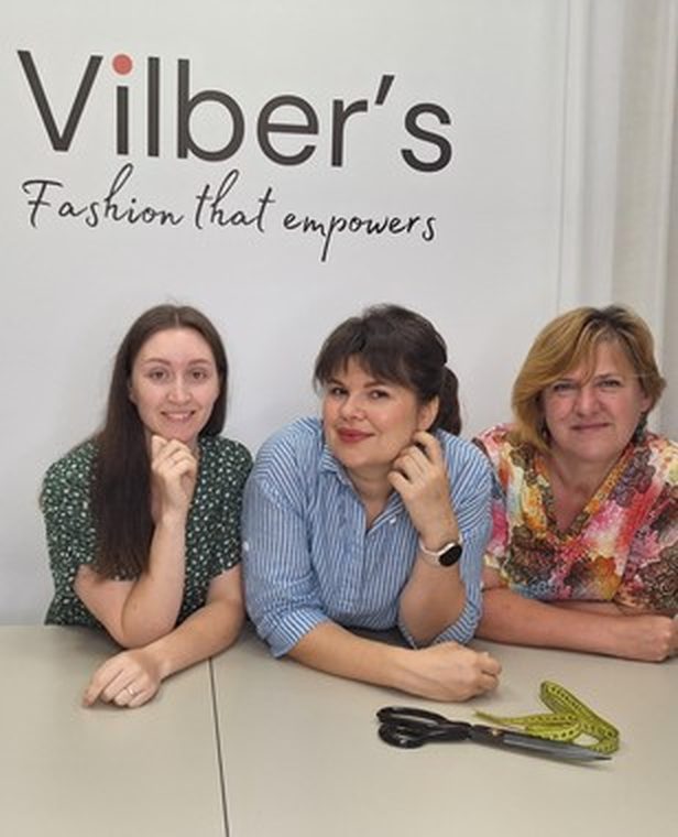 Drei Mitglieder des Vilber's-Teams an der Markenwand